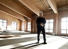 A man in a hard-hat stands proudly in  the construction of the Elkford CommunityCentre project.