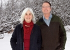 A man and woman stand in a snowy landscape