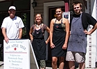 three people standing around a shop sign