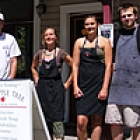 three people standing around a shop sign