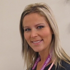 A blonde woman standing in a medical room.