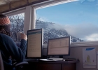 Person sitting in front of a computer by a window