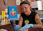 person giving a tattoo to another person