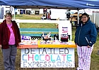 two ladies standing beside a chocolate stand