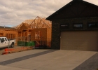 A house under construction beside a newly constructed home.