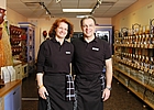 woman standing next to a man in a store with food in background
