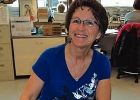 lady sitting at a desk taking notes and smiling