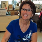 lady sitting at a desk taking notes and smiling