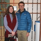 Photo of people standing next to a hot water tank.