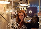 lady standing next to lighting and furniture pieces