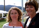 Two ladies standing side by side with paperwork in their hands