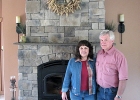 two people standing beside a fireplace