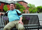A man sits on an outdoor bench.