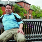 A man sits on an outdoor bench.