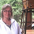 woman standing next to a home made bird house