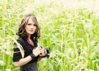 Natalie standing in a field with her camera.