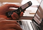 person on a computer with a cell
