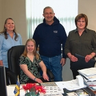 Rachel Gutwald sits at the mayor's desk in his city hall office.