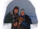 Charlie Sims, Sunny the dog and  Martina Danzer sitting in an igloo