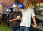 A man and a woman standing together holding a mug of coffee