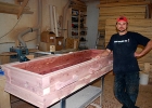 Zeabin standing beside a coffin he has built