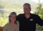 Man and woman on a deck in front of the mountains
