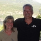 Man and woman on a deck in front of the mountains