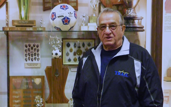 A man standing in front of a trophy case.
