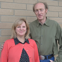 Woman and man in front of a brick wall