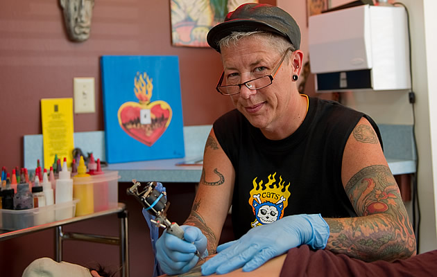 person giving a tattoo to another person