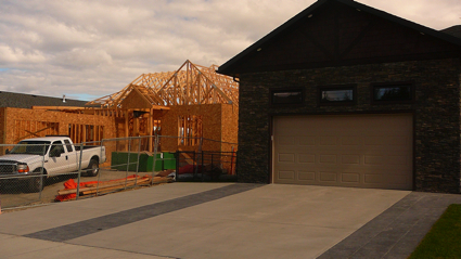 A house under construction beside a newly constructed home. 