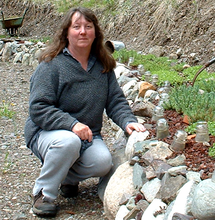Jacki Cammidge kneeling beside a garden