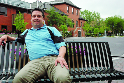 A man sits on an outdoor bench.