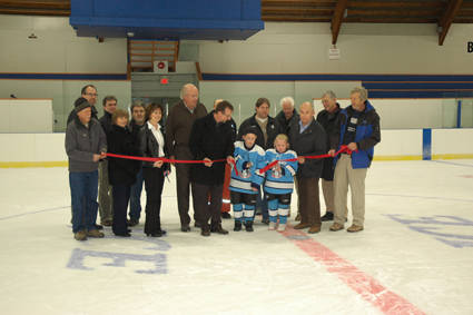 Two young hockey players cut ribbon in hockey arena