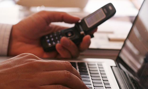 person on a computer with a cell