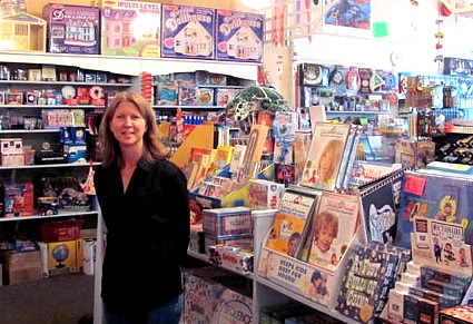 Kari Barkley stands in front of a selection of toys